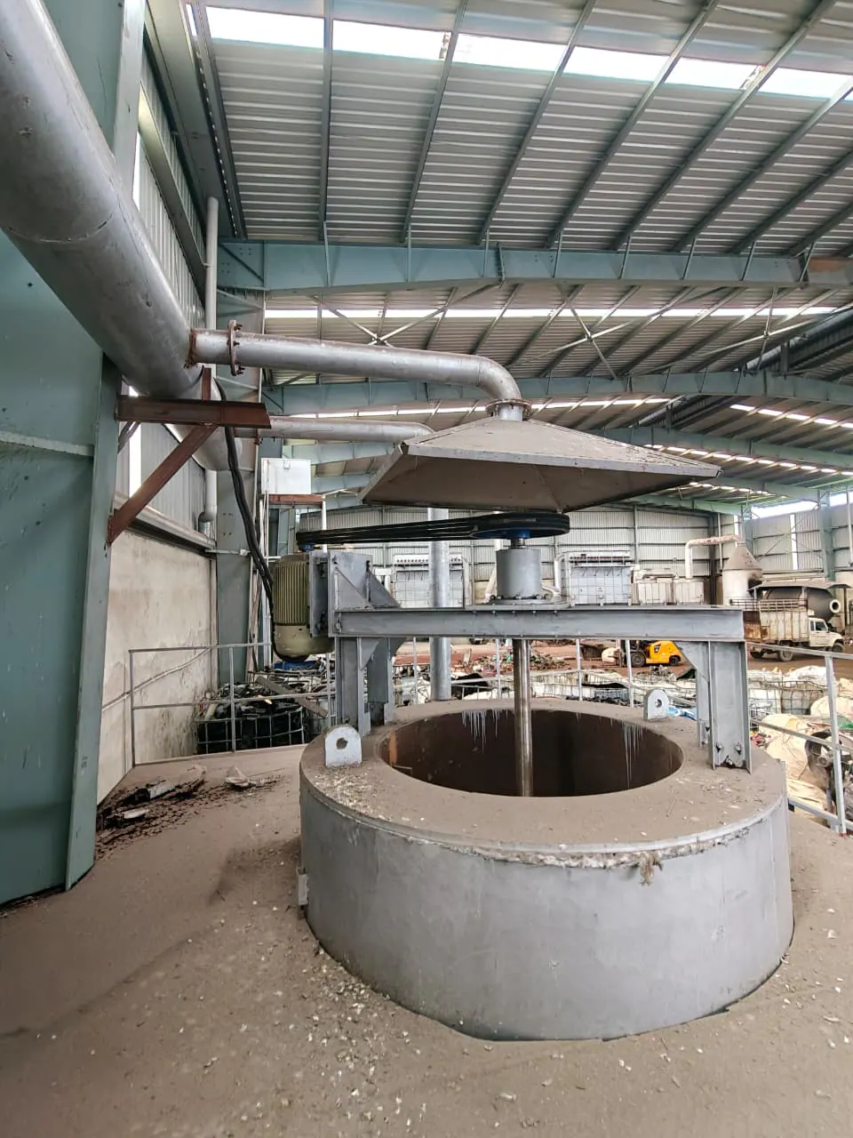 Portrait view of an agitated cylindrical vessel with an overhead extraction hood, belt drive and ducting