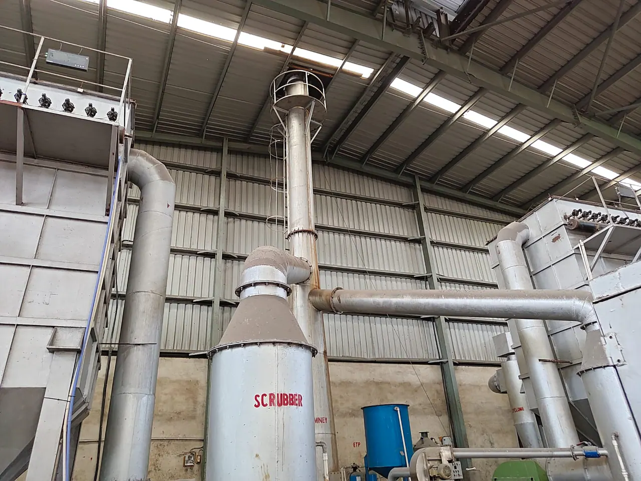 Tall wet scrubber and industrial stack connected by ducting between hopper-bottom filtration units